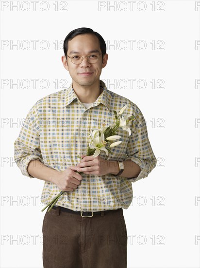Asian man holding bouquet of flowers