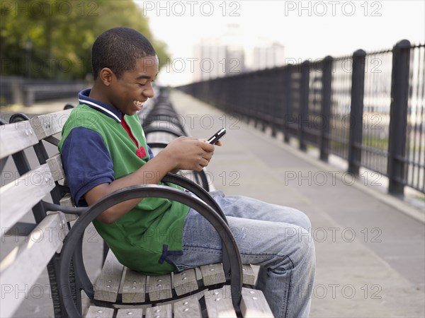 African teenager text messaging on cell phone