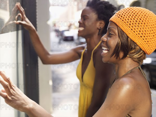 Smiling African friends window shopping