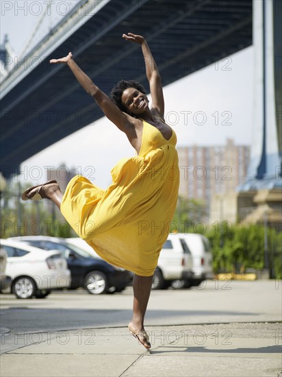 African woman jumping in mid-air in urban setting