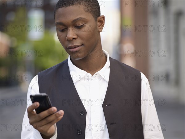 African man text messaging on cell phone