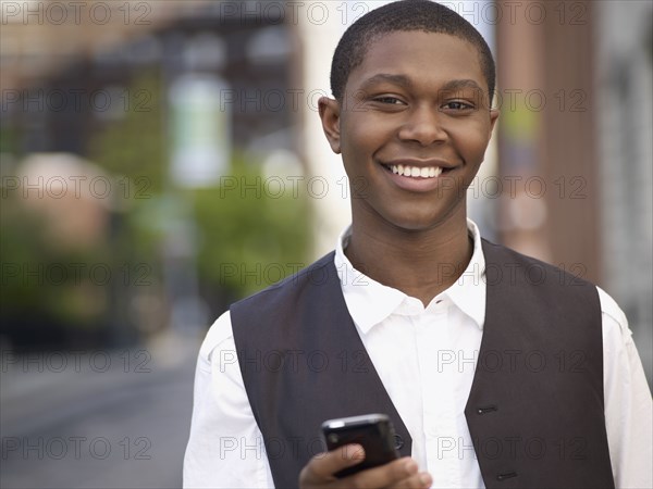 African man text messaging on cell phone