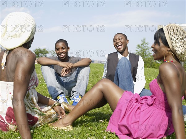 Laughing African friends sitting in park