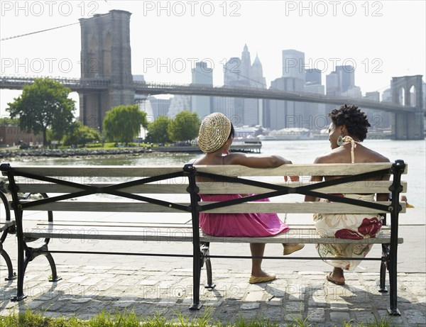 African women sitting on bench at urban waterfront