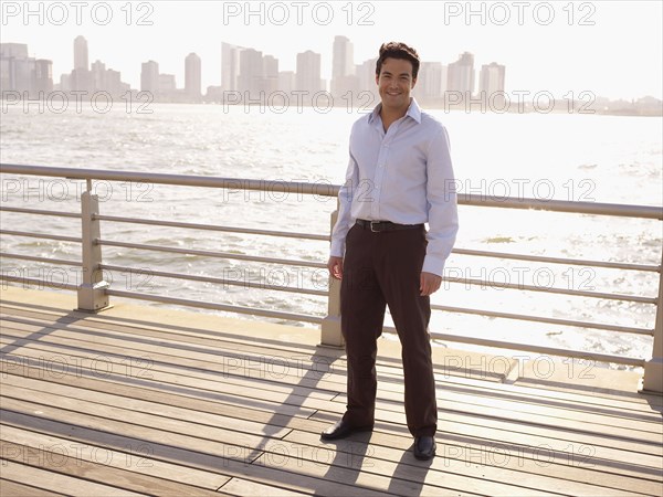 Man standing on boardwalk on waterfront