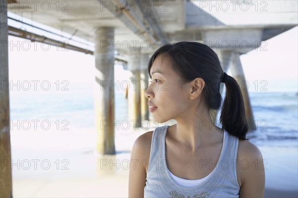 Asian woman under pier at beach