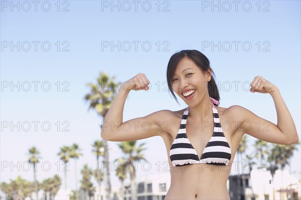 Asian woman wearing bikini showing muscles