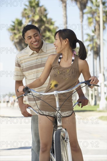 Young couple standing with tandem bicycle