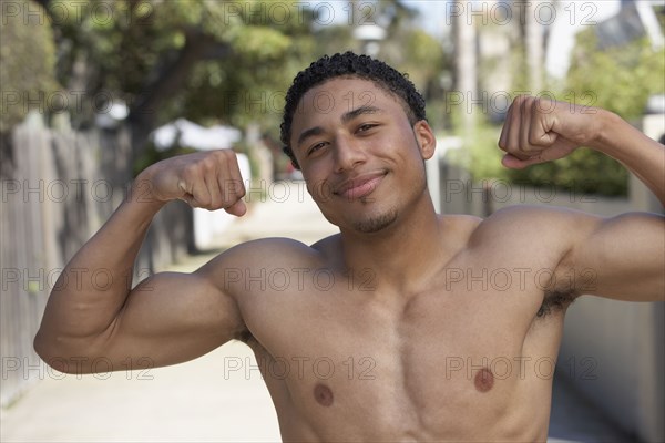 Young mixed race man with bare chest showing muscles