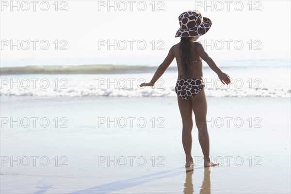 Young mixed race girl standing at beach