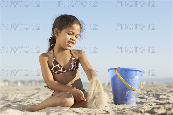 Young mixed race girl playing at beach