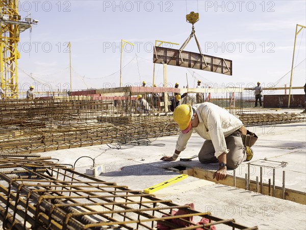Hispanic worker kneeling at construction site