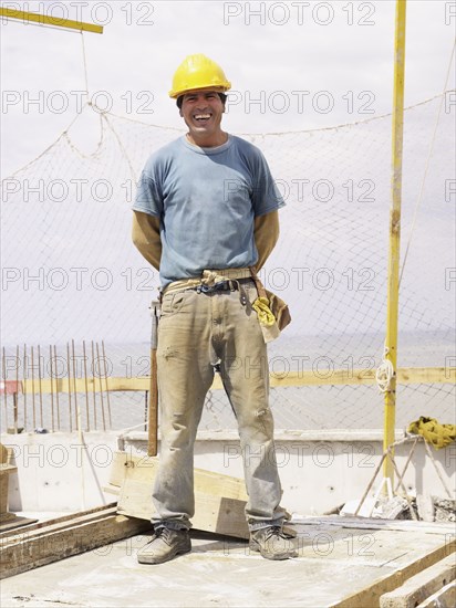 Hispanic worker smiling on construction site