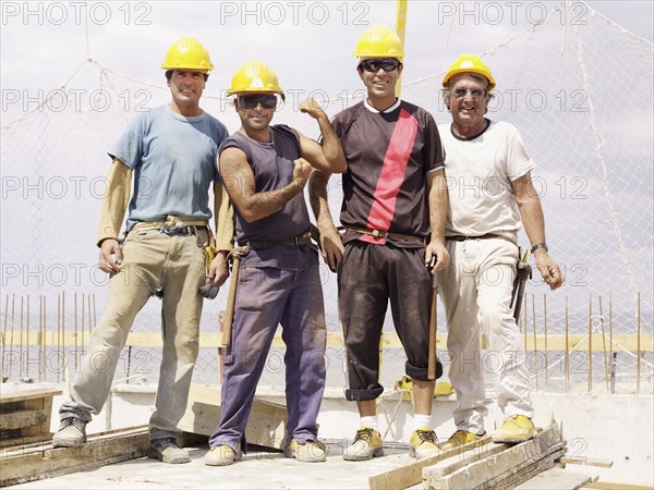 Hispanic workers standing on construction site