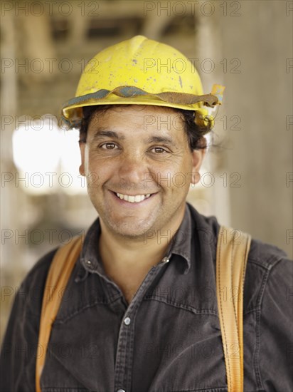 Hispanic worker smiling on construction site