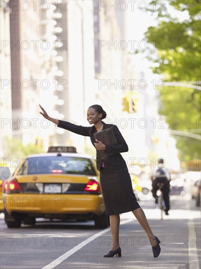 African businesswoman hailing taxi