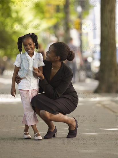 African businesswoman hugging girl