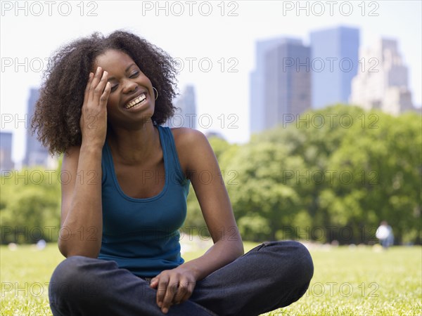 African woman laughing in park