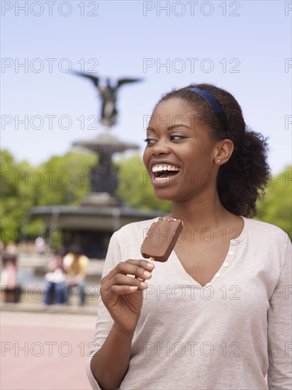 African woman eating ice cream bar