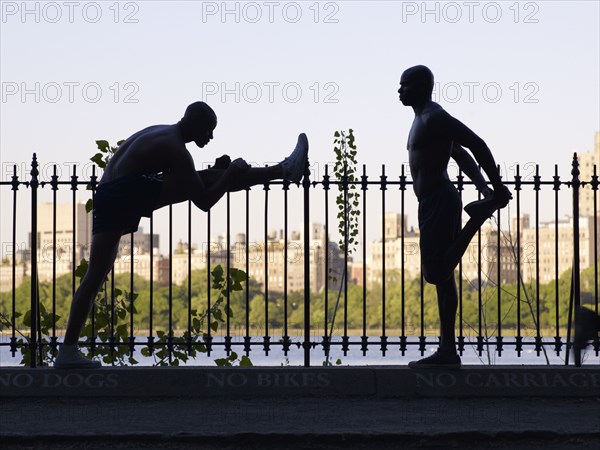 African men stretching on railing