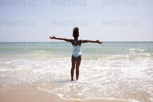 Jamaican girl wading on beach