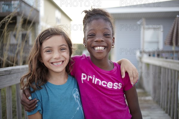 Grinning girls hugging outdoors