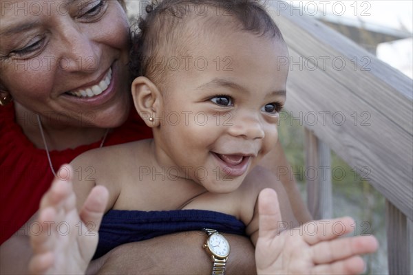 Smiling grandmother holding granddaughter outdoors