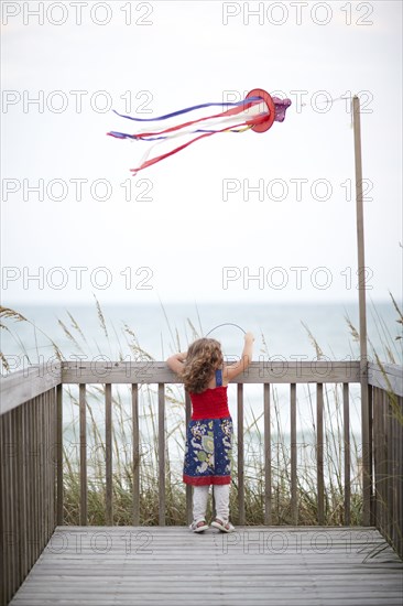 Girl standing on deck near ocean