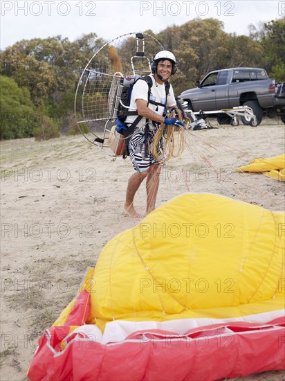 Hispanic man paragliding