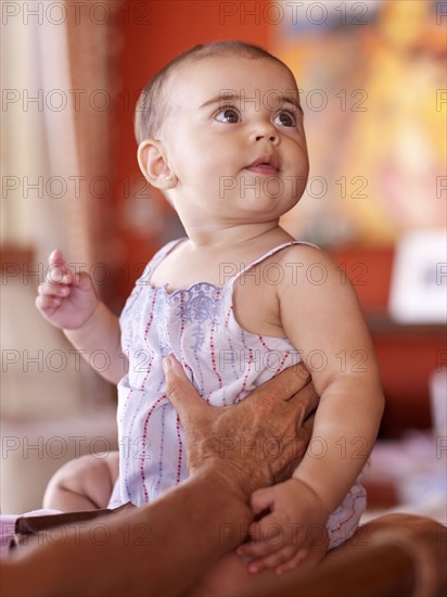 Hispanic grandmother holding baby granddaughter