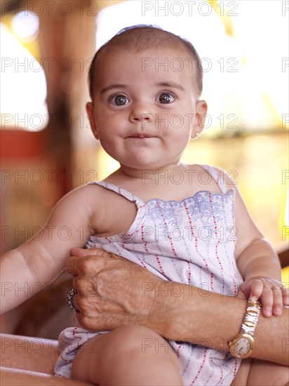 Hispanic grandmother holding baby granddaughter