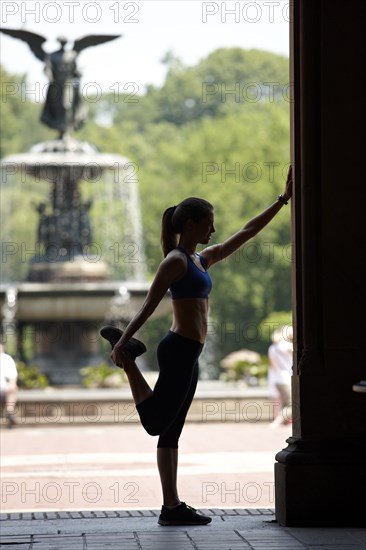 Caucasian woman stretching before exercise in park
