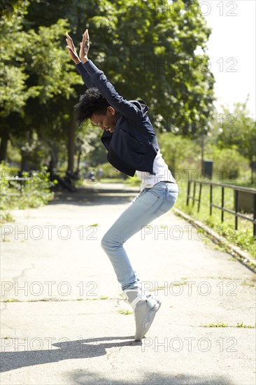 Black woman balancing on toes in park