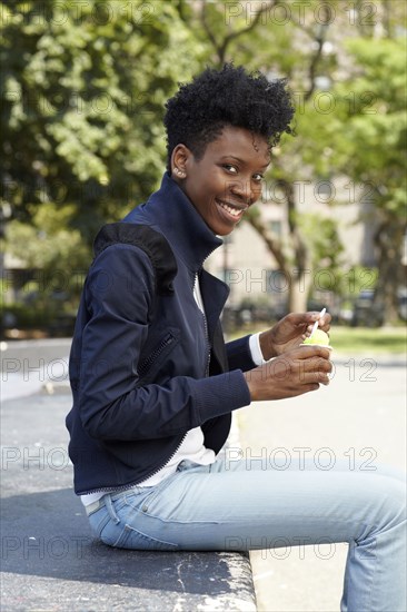Black woman eating ice cream in park