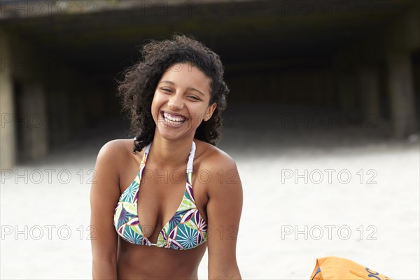 Laughing mixed race woman on beach