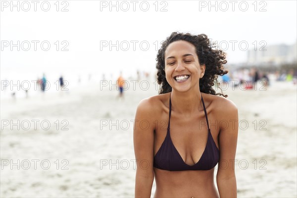 Smiling mixed race woman on beach