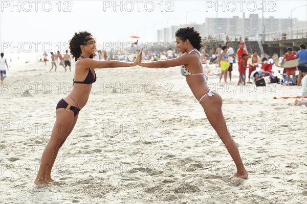 Mixed race friends playing on beach