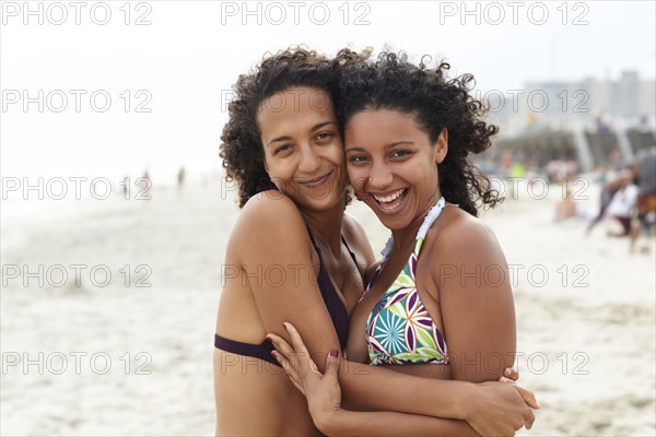 Mixed race friends hugging on beach