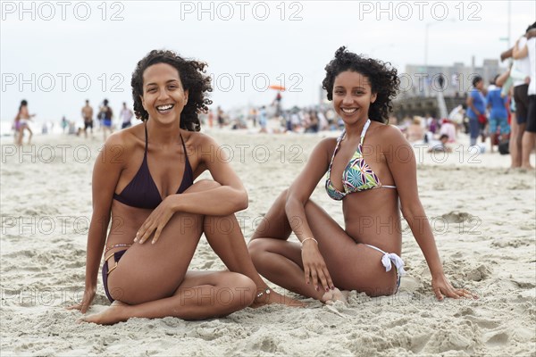 Mixed race friends sitting on beach