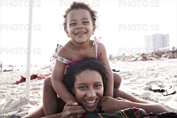 Mixed race mother and daughter enjoying the beach