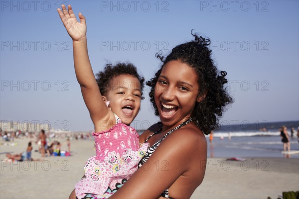 Mixed race mother and daughter enjoying the beach