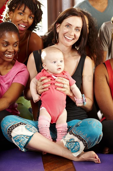 Woman holding baby in yoga class