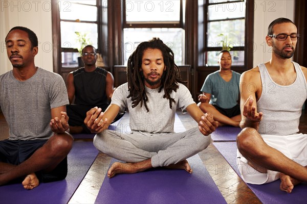 Men meditating in yoga class