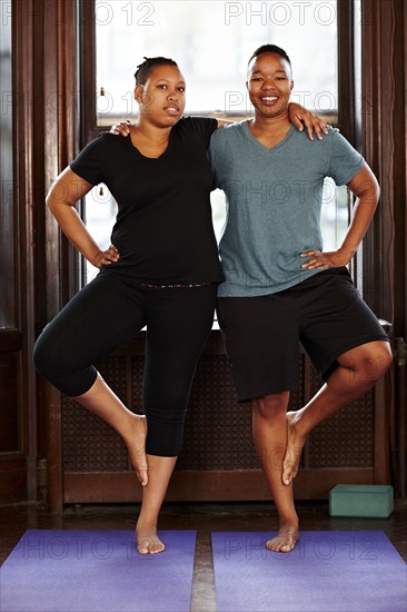 Women balancing together in yoga class