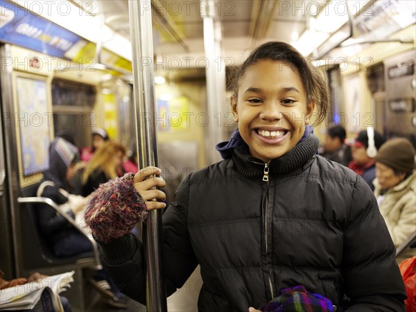 Mixed race girl smiling on subway