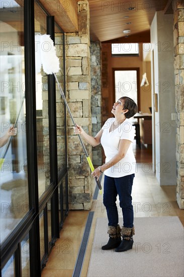 Hispanic woman dusting windows