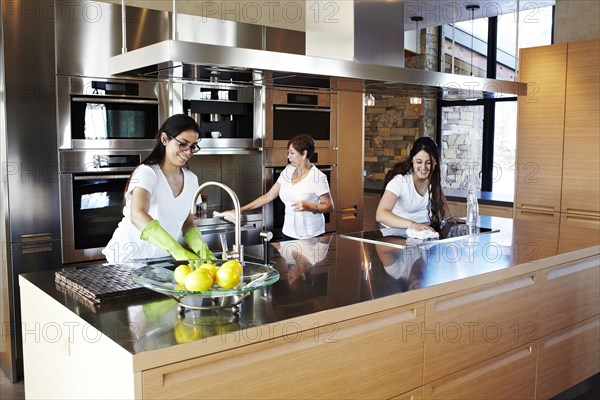 Hispanic women cleaning kitchen