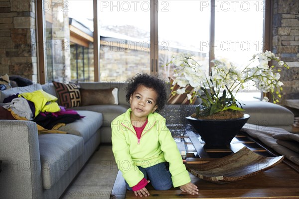 Mixed race girl sitting on coffee table