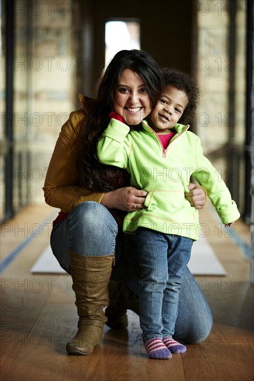 Mother and daughter smiling in hallway