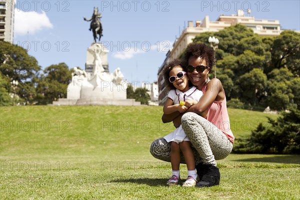 Mother and daughter smiling in park